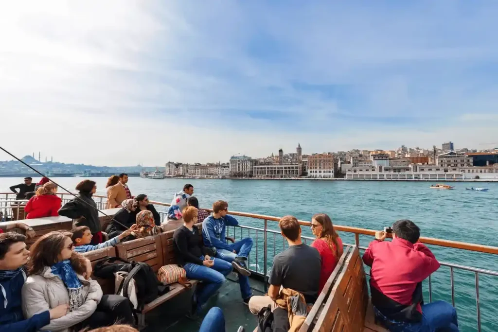 Tourists on a Bosphorus cruise, enjoying the scenic views and lively environment of Istanbul’s waterfront.