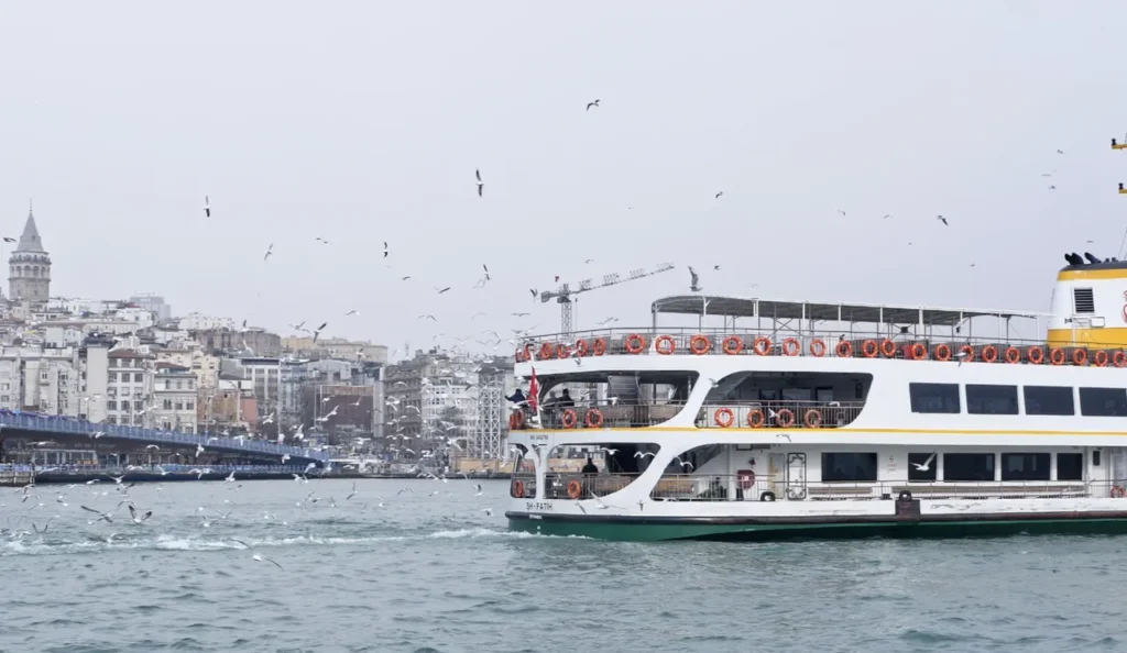 A ferry cruising on the Bosphorus in Istanbul, with city skyline views.