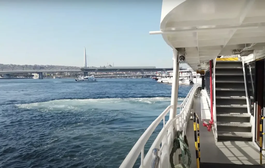 A view of the Bosphorus from a ferry, with the city’s skyline and a bridge in the background.