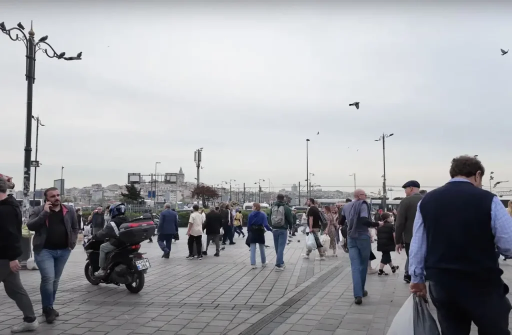 Eminönü Square in Istanbul on a cloudy day, with a backdrop of historic buildings and the waterfront.
