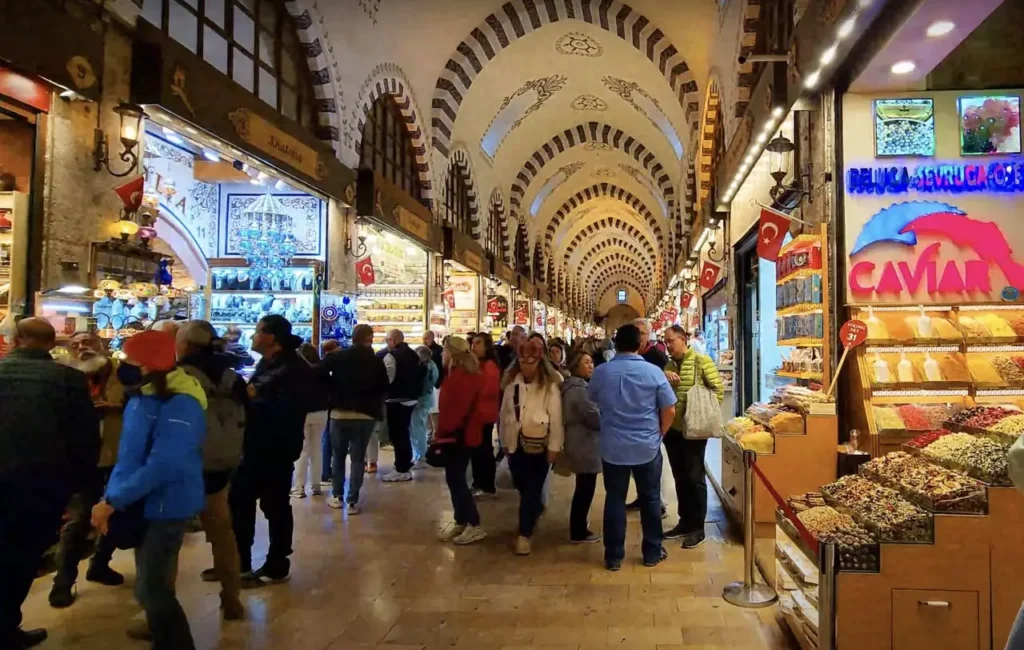 The main hall of the Spice Bazaar in Istanbul, with bustling shops and colorful displays.
