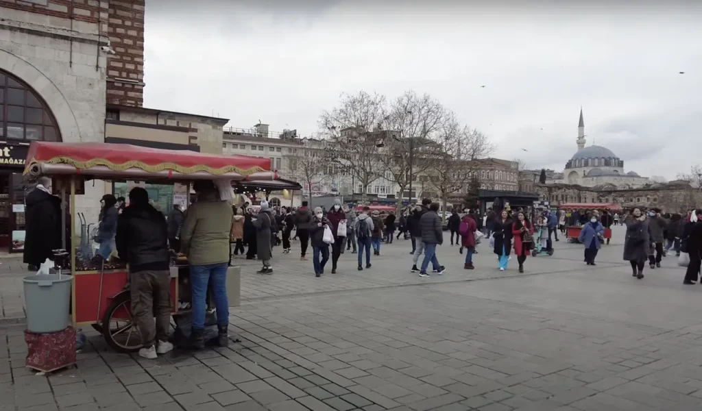A view of Eminönü Square in Istanbul, with a chestnut vendor and the bustling city in the background.