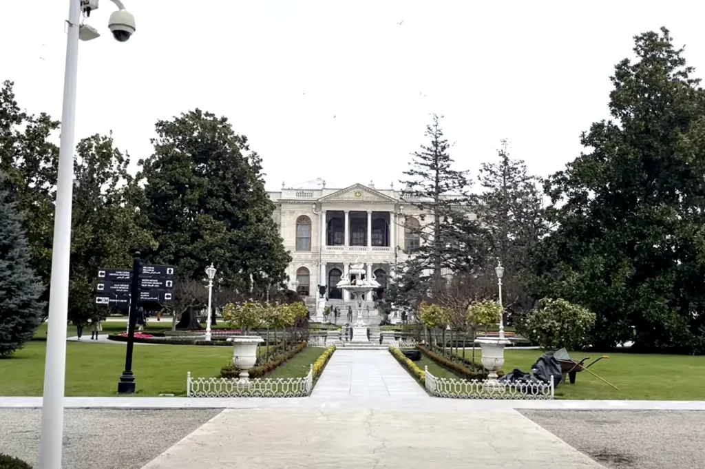 The entrance to Dolmabahçe Palace, viewed from its gardens, leading to the majestic palace.