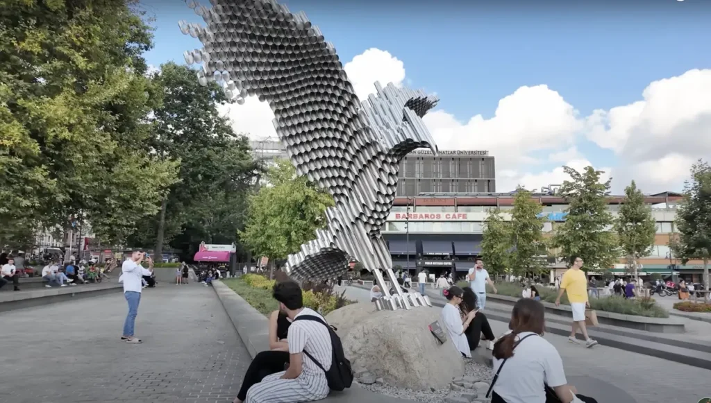 A sculpture in Beşiktaş Square, surrounded by the lively urban environment of Istanbul’s Beşiktaş district.