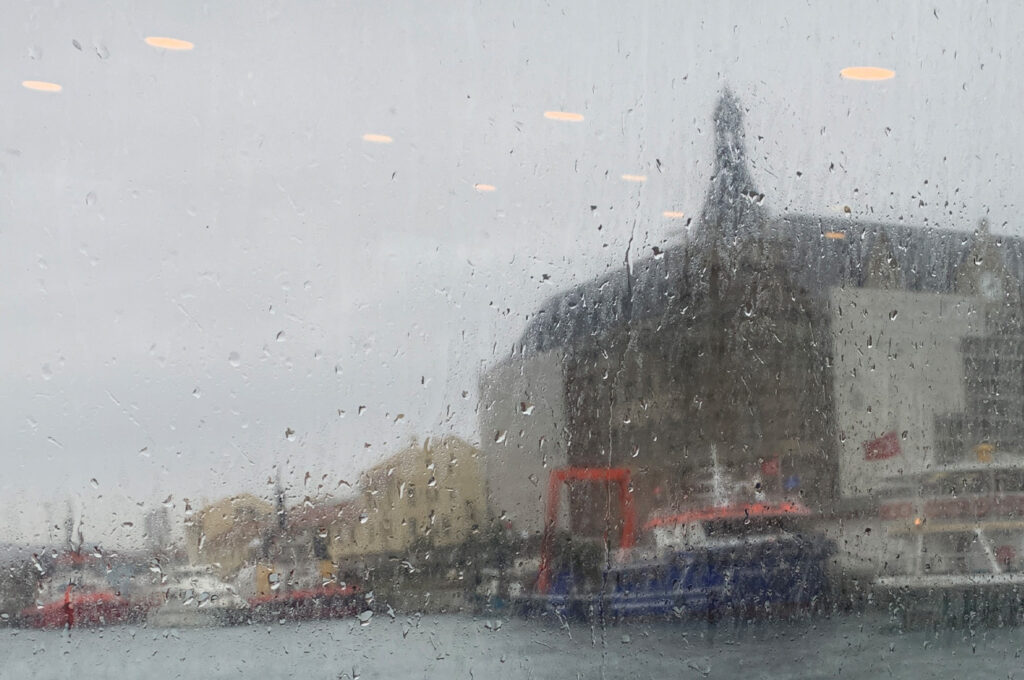 Haydarpaşa Railway Station in Istanbul, seen from a ferry window on a rainy day.