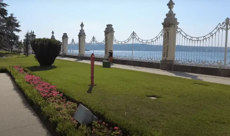 View from Dolmabahçe Palace garden to the Bosphorus, with flowers and calm waters.