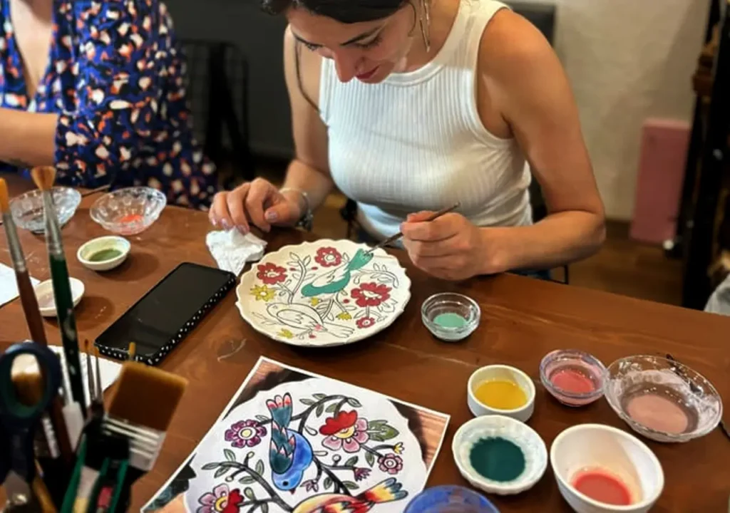 Creating art on Turkish ceramics in a workshop.