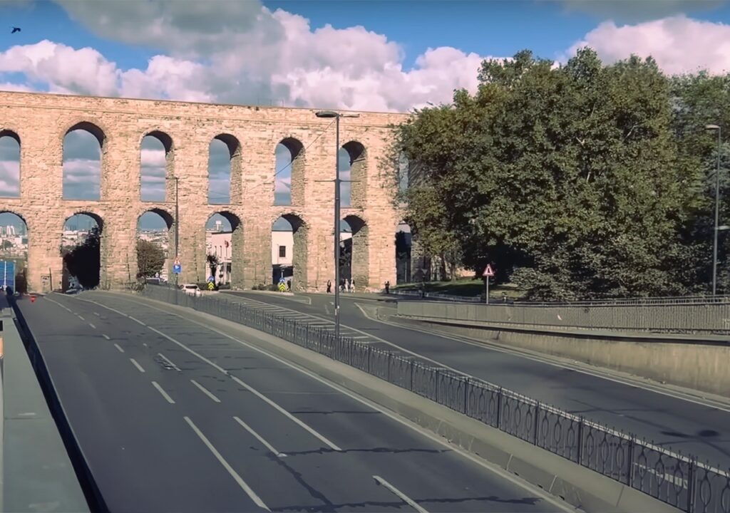 The Aqueduct of Valens as seen from a nearby road, with traffic passing underneath.