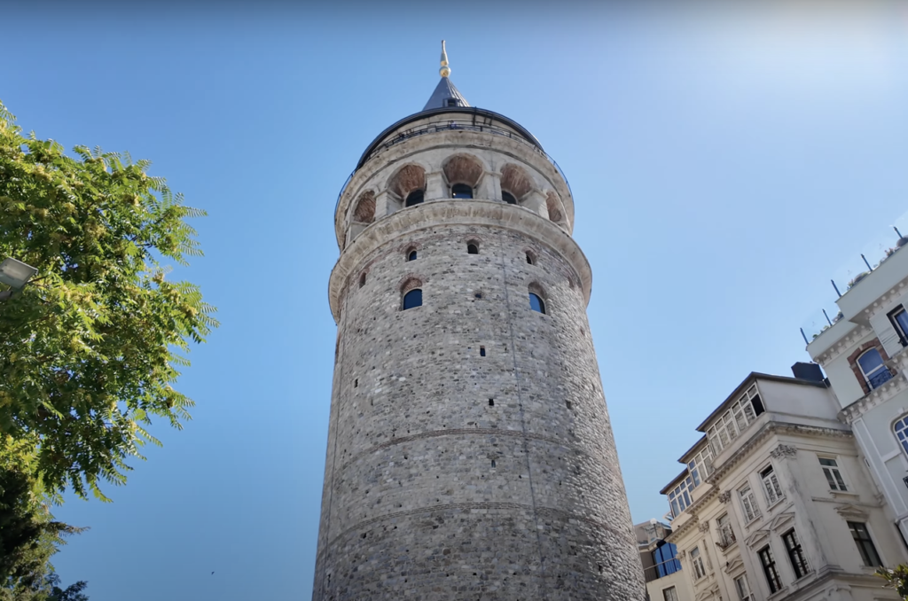 A view of Galata Tower from the ground, looking up at the historic structure.